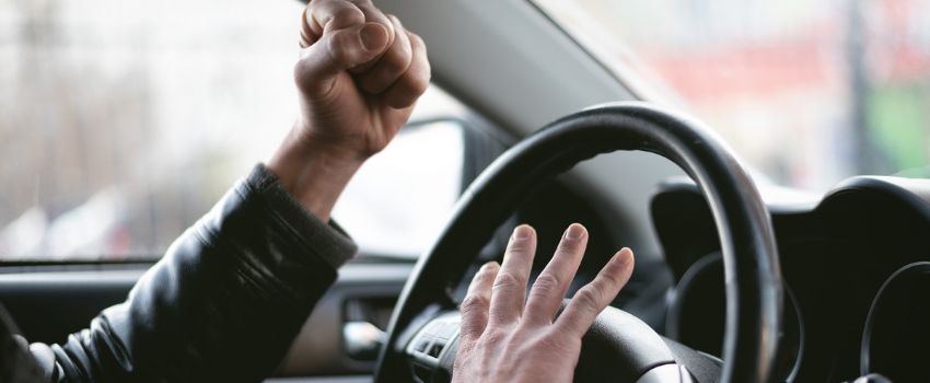 Uomo in auto che impreca e batte i pugni sul volante