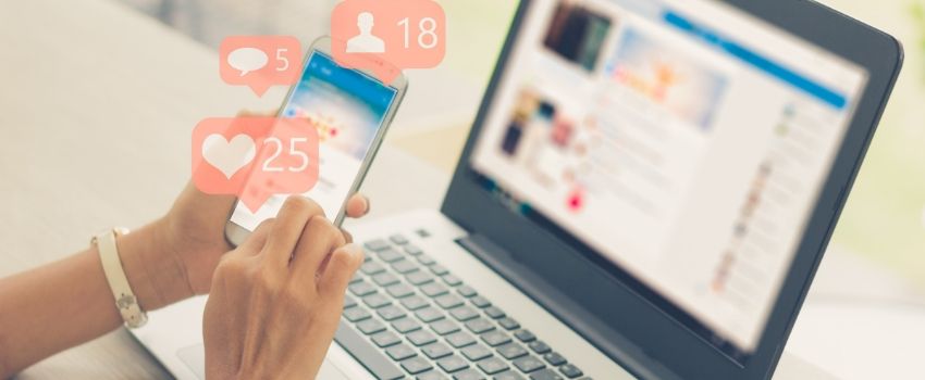 Social Media _850x350 Persona che naviga con lo smartphone mentre è al lavoro